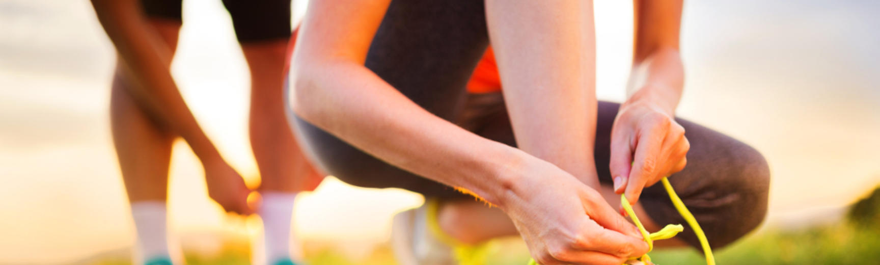 Close up photo of a runner lacing up their trainers