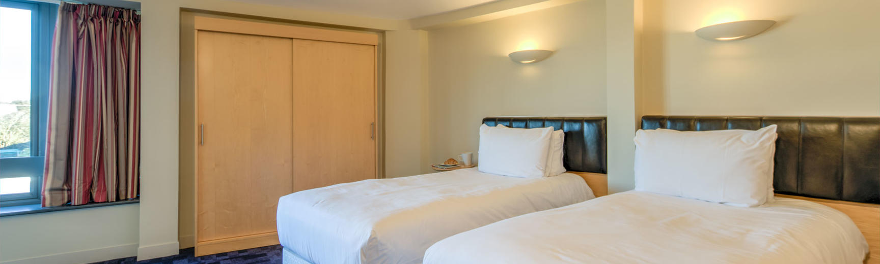 Photo of a room with two single beds and a wardrobe