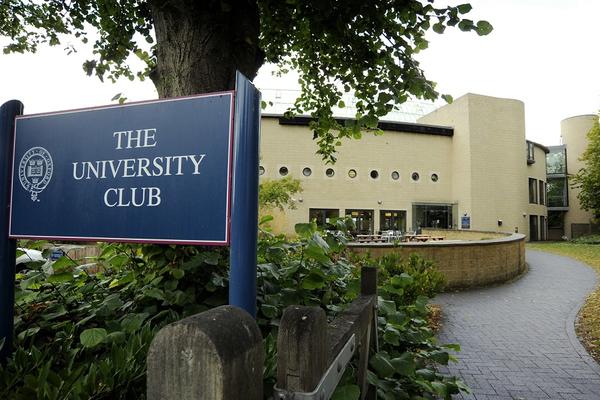 Photo of a blue sign reading 'The University Club' in white text, outside the front of the Club